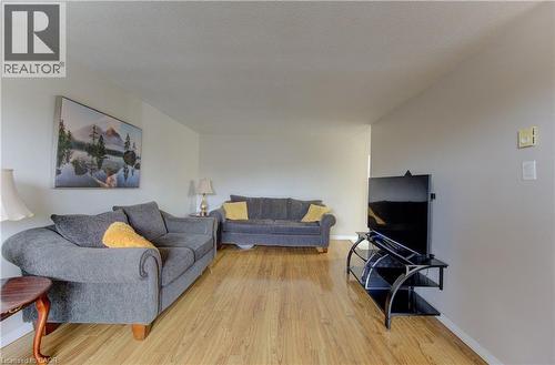 Living area featuring light wood-style flooring and a textured ceiling - 4 Avalon Place Unit# 103, Kitchener, ON - Indoor Photo Showing Living Room