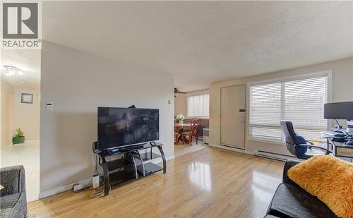 Office with a textured ceiling, light wood-type flooring, and baseboard heating - 4 Avalon Place Unit# 103, Kitchener, ON - Indoor Photo Showing Living Room