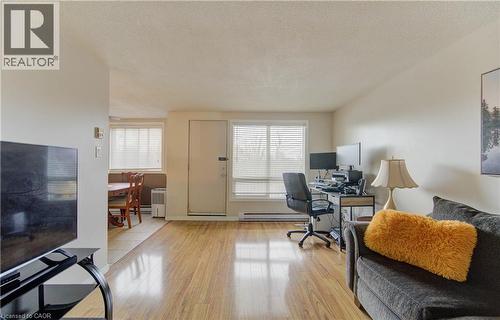 Office featuring a textured ceiling, light wood-style flooring, and a baseboard radiator - 4 Avalon Place Unit# 103, Kitchener, ON - Indoor