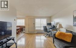 Office featuring a textured ceiling, light wood-style flooring, and a baseboard radiator - 