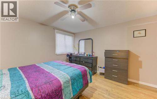 Bedroom featuring wood finished floors, a textured ceiling, and a ceiling fan - 4 Avalon Place Unit# 103, Kitchener, ON - Indoor Photo Showing Bedroom
