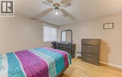 Bedroom featuring wood finished floors, a textured ceiling, and a ceiling fan - 