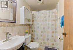 Full bath featuring vanity, tile walls, and a shower with shower curtain - 