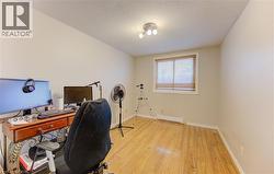 Office area with light wood-type flooring, a textured ceiling, and baseboard heating - 