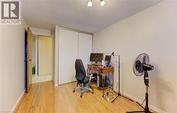 Office space featuring light wood-type flooring and a textured ceiling - 