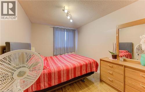 Bedroom featuring light wood-type flooring and a textured ceiling - 4 Avalon Place Unit# 103, Kitchener, ON - Indoor Photo Showing Bedroom