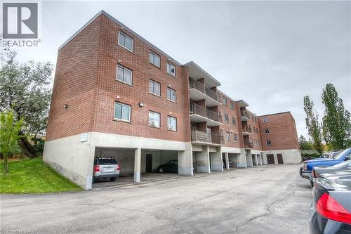 View of apartment building / complex featuring a parking lot - 4 Avalon Place Unit# 103, Kitchener, ON - Outdoor With Balcony