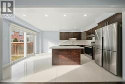 Kitchen with stainless steel appliances, a center island, dark brown cabinetry, tasteful backsplash, and recessed lighting - 