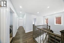 Corridor with an upstairs landing, washer / dryer, recessed lighting, and dark wood-style flooring - 
