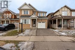 View of front of house featuring driveway, a porch, an attached garage, and brick siding - 