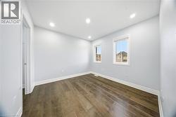 Empty room with dark wood-style flooring and recessed lighting - 