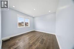 Spare room with dark wood-type flooring and recessed lighting - 