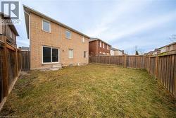 Back of property with brick siding and a fenced backyard - 