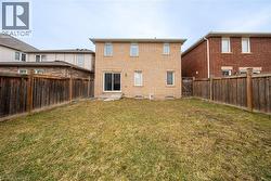 Back of property with brick siding and a fenced backyard - 