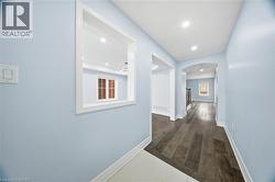 Hallway featuring arched walkways, recessed lighting, and dark wood-style flooring - 