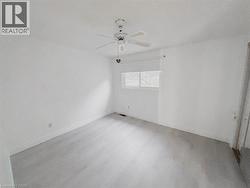 Empty room with wood finished floors and ceiling fan - 
