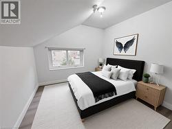 Bedroom with lofted ceiling and wood finished floors - 