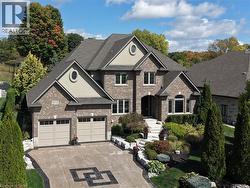 View of front of house with brick siding, concrete driveway, stucco siding, and a garage - 