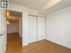 Unfurnished bedroom featuring wood finished floors, a closet, and a textured ceiling - 
