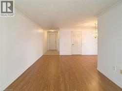 Spare room with crown molding, light wood-style flooring, a chandelier, and a textured ceiling - 