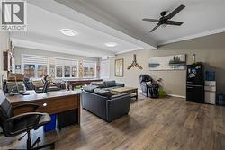 Office space featuring ornamental molding, dark wood-style floors, a ceiling fan, billiards, and beamed ceiling - 
