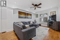 Living area with light wood-style flooring, ornamental molding, a ceiling fan, and recessed lighting - 
