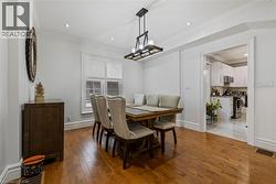 Dining room with light wood-style floors, ornamental molding, recessed lighting, and a chandelier - 