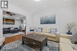 Living area featuring ornamental molding, wood finished floors, recessed lighting, and a ceiling fan - 