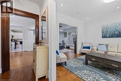 Living area featuring ornamental molding and dark wood-type flooring - 