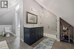 Bathroom featuring vaulted ceiling, vanity, and a stall shower - 