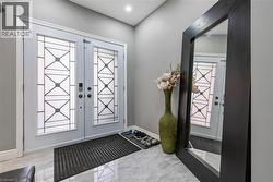 Foyer entrance featuring light marble finish flooring and french doors - 