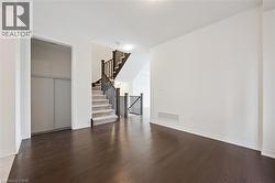 Unfurnished living room with hardwood / wood-style flooring and stairway - 