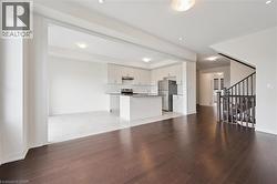 Unfurnished living room with light wood-style flooring and stairway - 