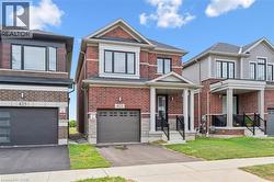 Traditional home featuring driveway, brick siding, a garage, and a front yard - 