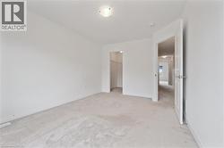 Unfurnished bedroom with a spacious closet and light colored carpet - 