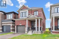 View of front of house with brick siding, a garage, a front yard, and driveway - 