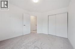 Unfurnished bedroom featuring carpet flooring and a closet - 