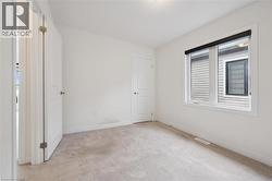 Unfurnished bedroom with light colored carpet and baseboards - 
