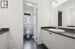 Bathroom featuring vanity and dark tile patterned floors - 