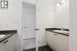 Bathroom with two vanities and dark tile patterned flooring - 