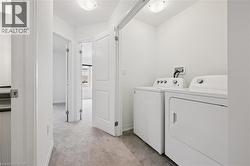 Laundry area with washer and clothes dryer and light carpet - 