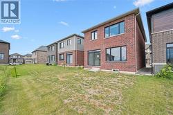 Rear view of house with brick siding, a lawn, a residential view, and entry steps - 