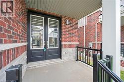 Property entrance with french doors, covered porch, and brick siding - 