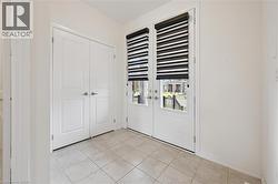 Foyer entrance with french doors and light tile patterned floors - 