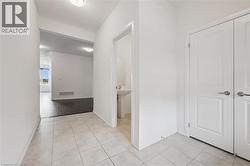 Hallway with baseboards and light tile patterned flooring - 