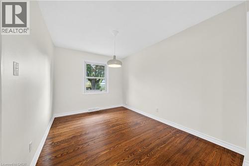 Empty room with dark wood-style floors and baseboards - 421 East 36Th Street, Hamilton, ON - Indoor Photo Showing Other Room