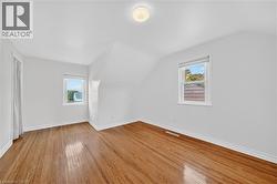 Additional living space with lofted ceiling, plenty of natural light, and light wood-style floors - 