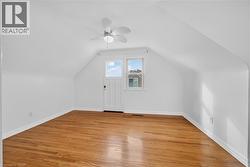 Additional living space featuring light wood finished floors, vaulted ceiling, and ceiling fan - 