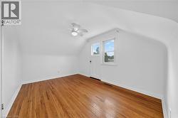 Bonus room with light wood-type flooring and vaulted ceiling - 
