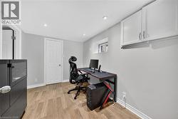 Office with light wood-style floors and recessed lighting - 